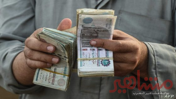 An Egyptian cattle trader counts his money at the Ashmun market in Egypt's Menufia Governorate on August 15, 2018, as they gather to sell livestock to customers ahead of the annual Muslim Eid al-Adha holiday when custom requires the faithful to make a sacrifice. - Muslims around the world will mark the upcoming Eid al-Adha, as the biggest holiday of the Islamic calendar, celebrated the Islamic festival Eid al-Adha by slaughtering sheep, goats, cows and camels to commemorate Prophet Abraham's willingness to sacrifice his son Ismail on God's command. (Photo by Mohamed el-Shahed / AFP)